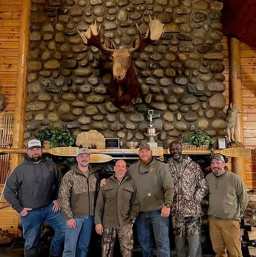Participants gathered in a stone-fireplace lodge beneath a moose mount