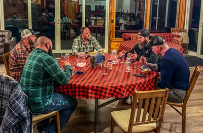 Hunters talk around a table at a lodge dinner.