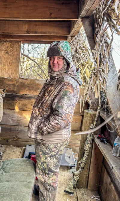 A hunter smiles in a duck blind.
