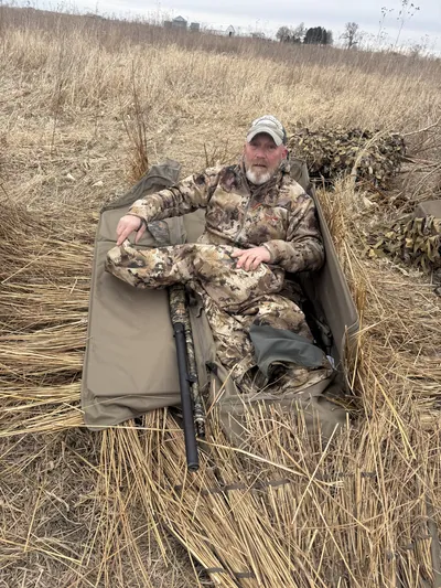 A hunter relaxes in a layout blind.