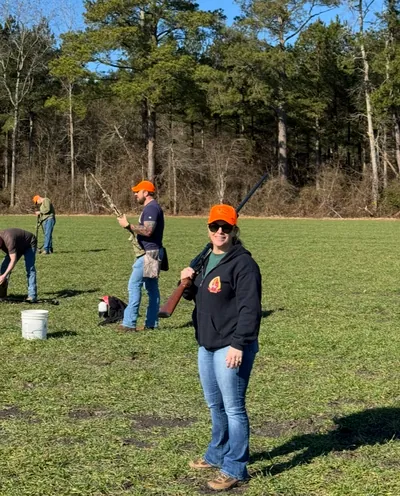 A hunter in a Comanche Outdoors hoodie stands in a field.