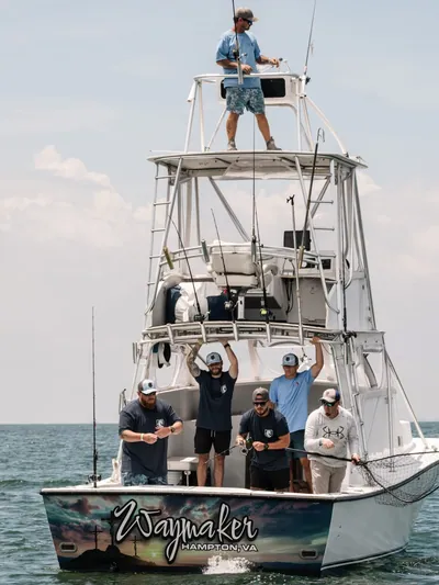 A charter crew celebrates on the stern of a boat.